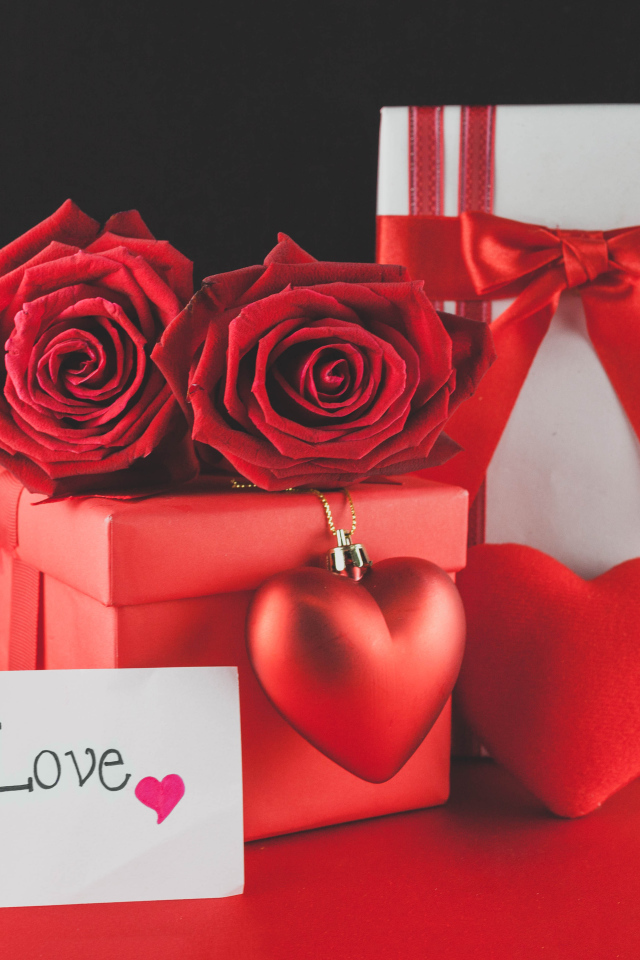 Коробки с подарками на столе с красными розами и сердцем