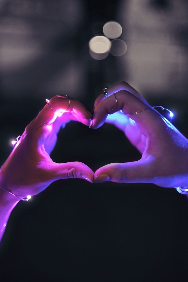 Девушка делает сердце руками