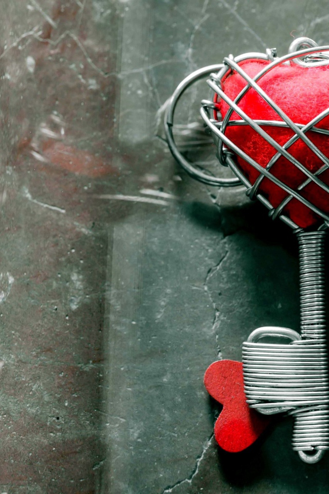 Ключ с красным сердцем на сером столе