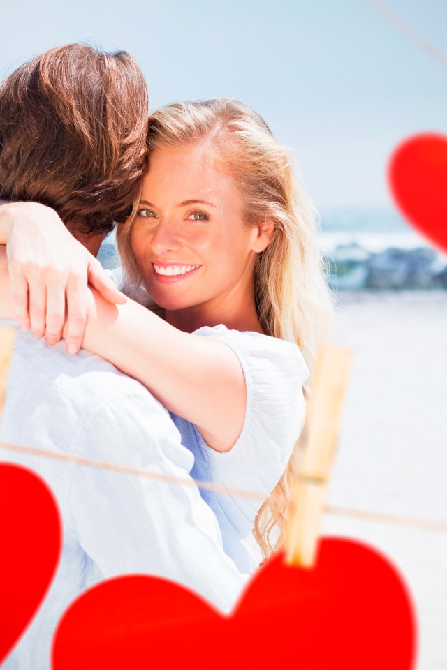 Loving couple with red hearts on the ocean