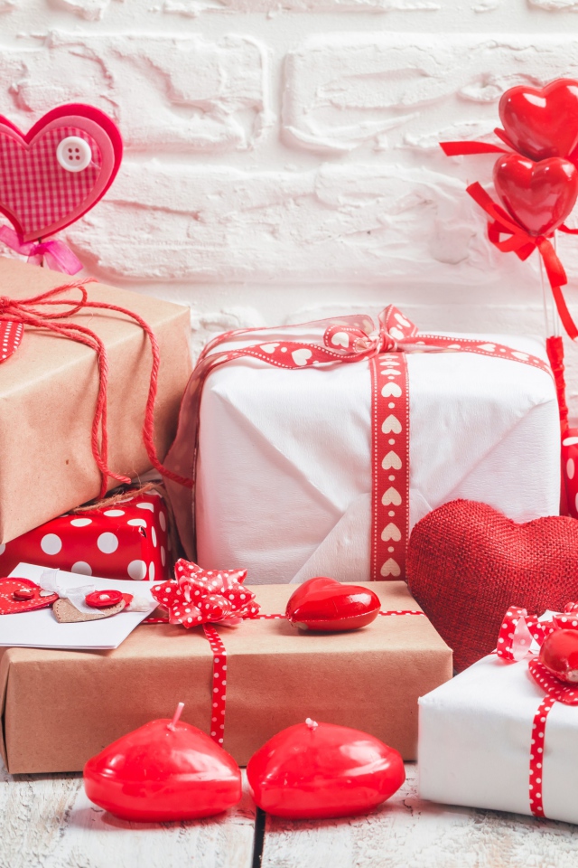 Много  подарочных коробок с сердечками на фоне стены