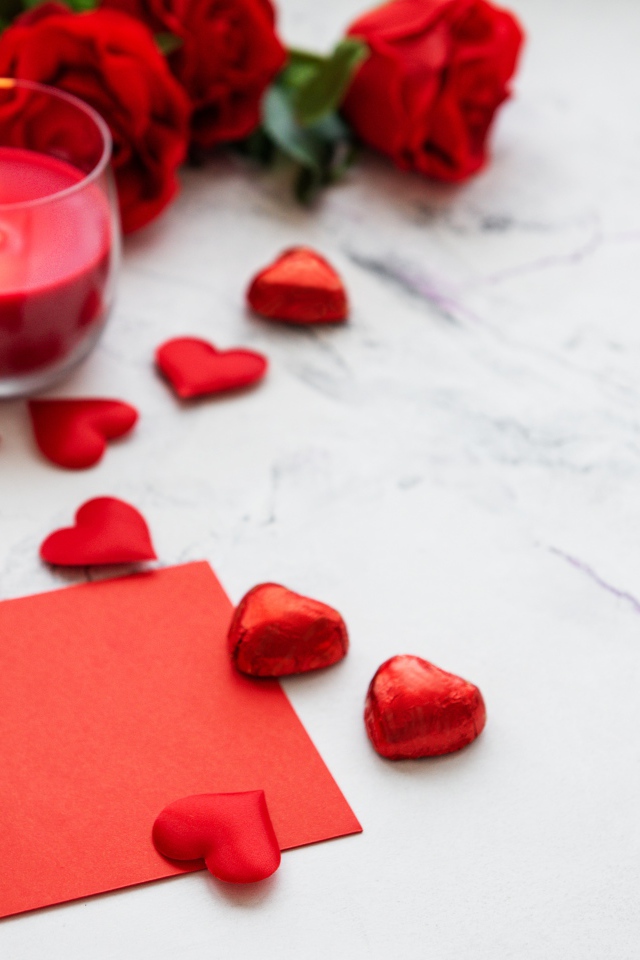 Красные сердечки, зажженная свеча и розы для любимой