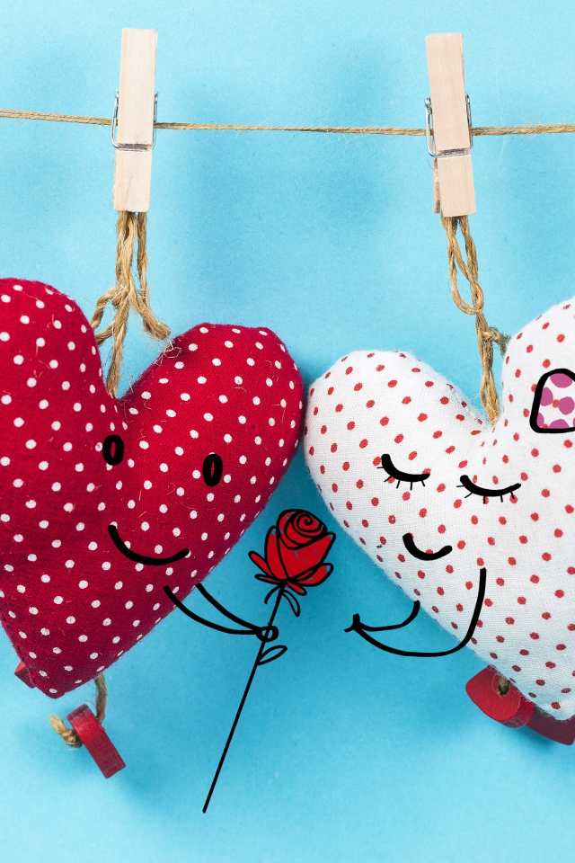 Два сердечка на прищепках на веревке на голубом фоне