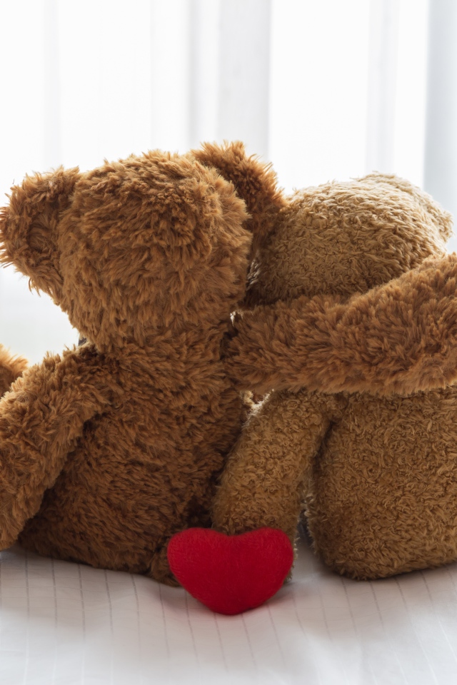 Два влюбленных плюшевых медвежонка на кровати