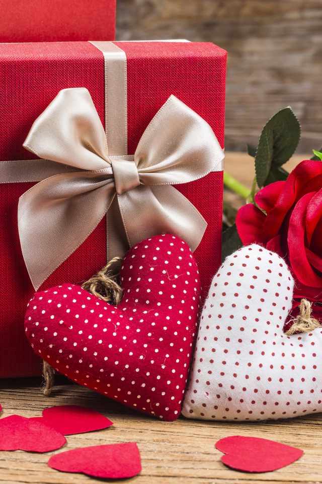 Два мягких сердечка на столе с подарком и розами для любимой