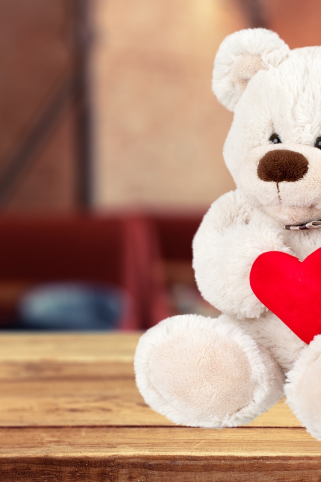 Белый плюшевый мишка с красным сердцем