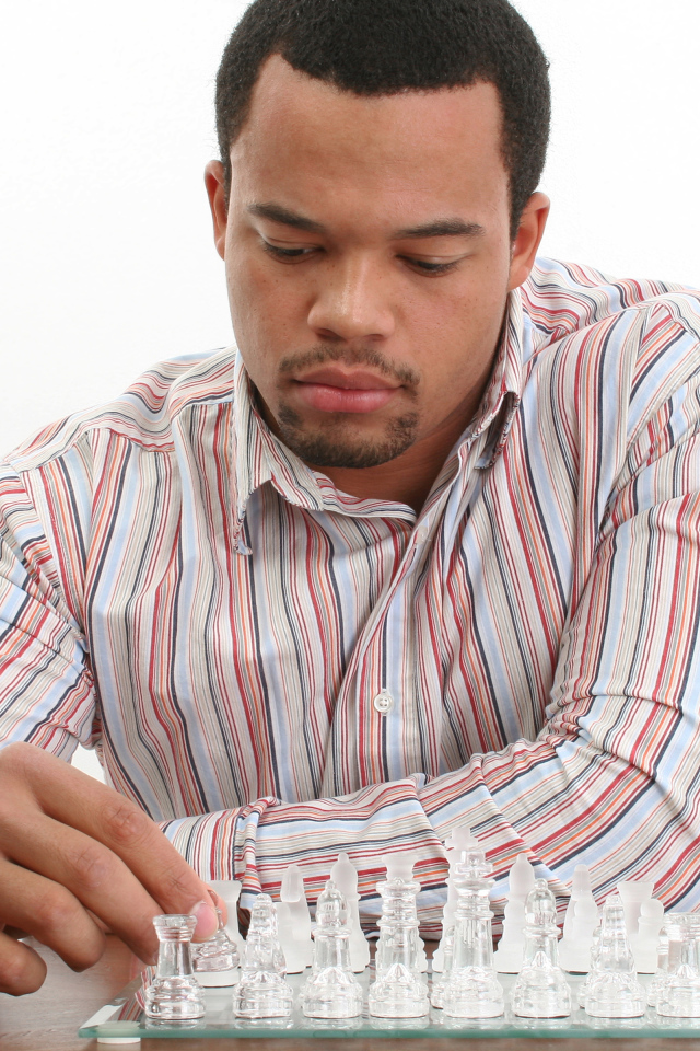 Мужчина в рубашке играет в стеклянные шахматы