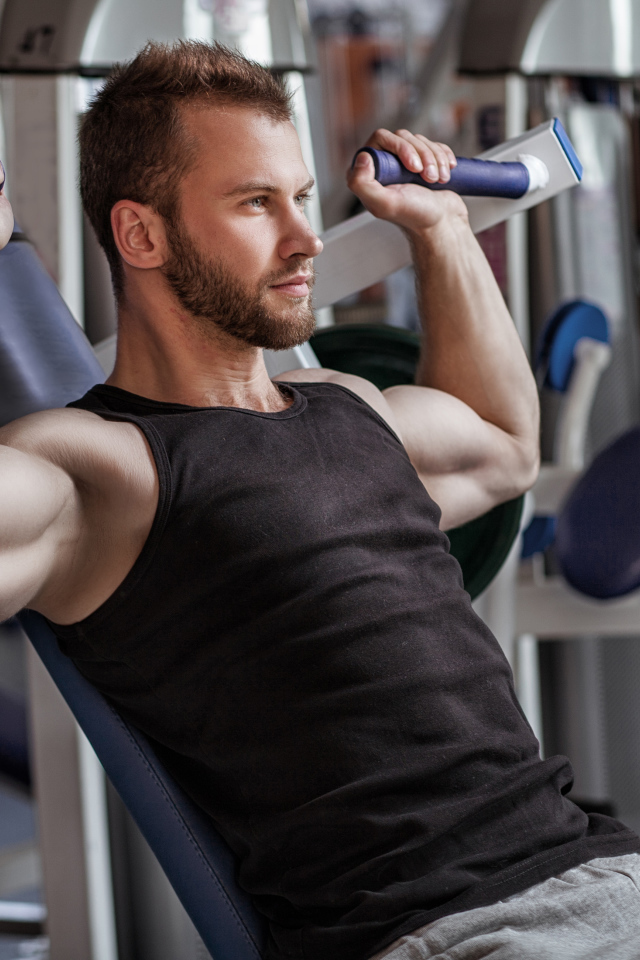 A muscled man is engaged in the gym