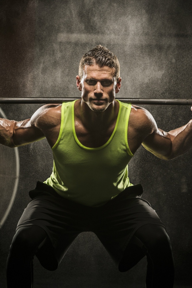 Мужчина спортсмен со штангой на плечах 