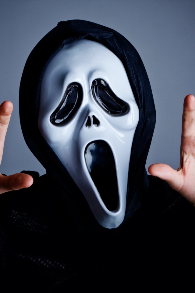Man in mask scares on gray background