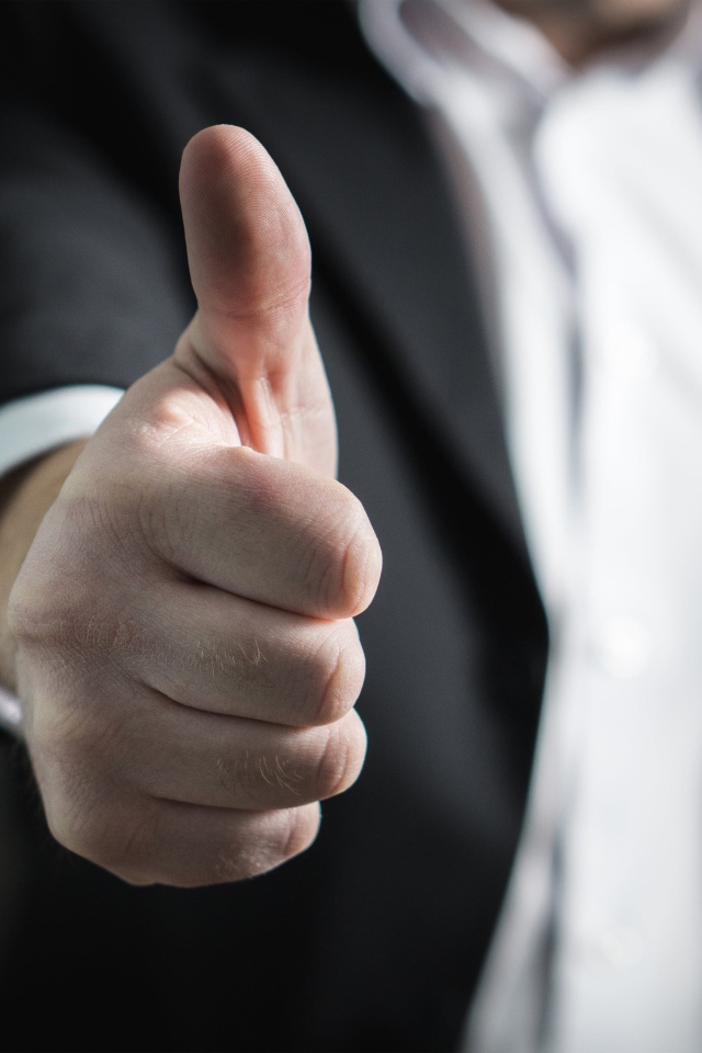 Мужчина в костюме показывает класс пальцем