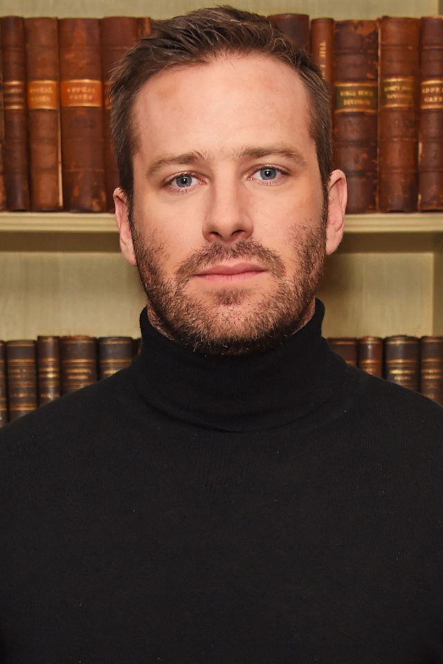 Актер Арми Хаммер стоит у библиотеки