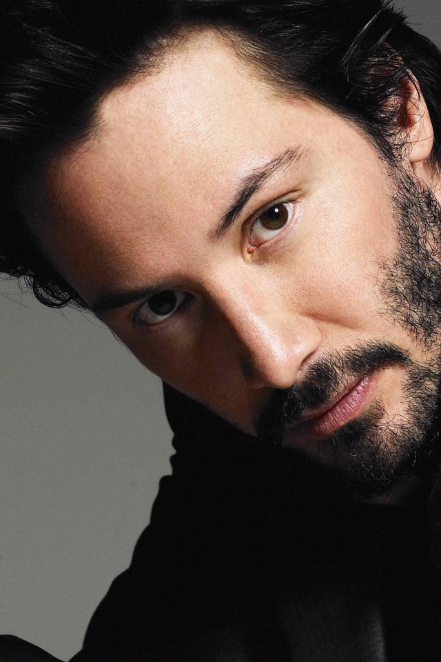 Актер Киану Ривз в костюме на сером фоне