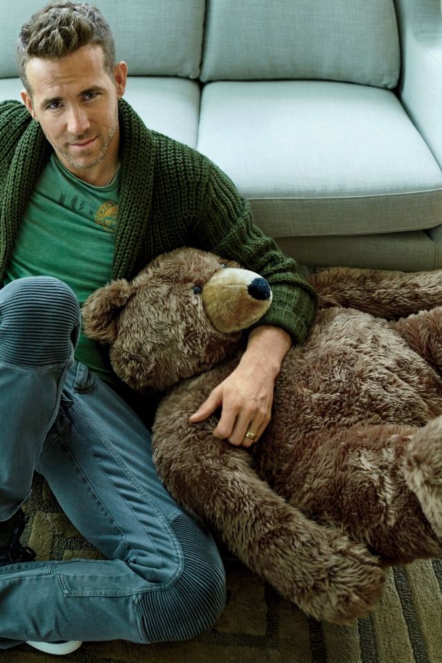 Актер Райан Рейнольдс с большим плюшевым медведем сидит на полу