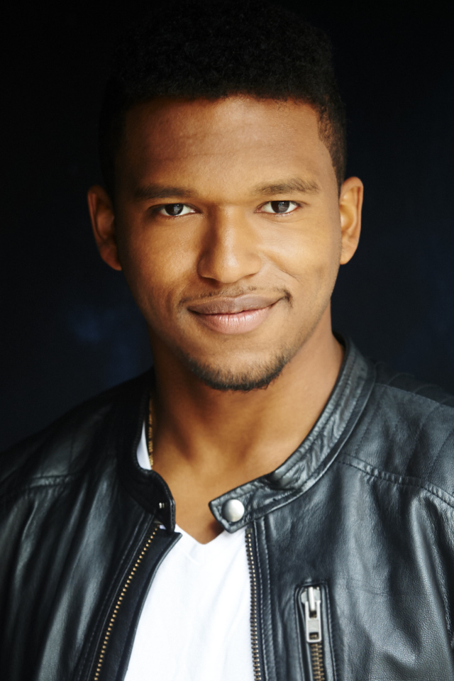 Красивый мужчина в черной куртке, актер Ловелл Адамс-Грей