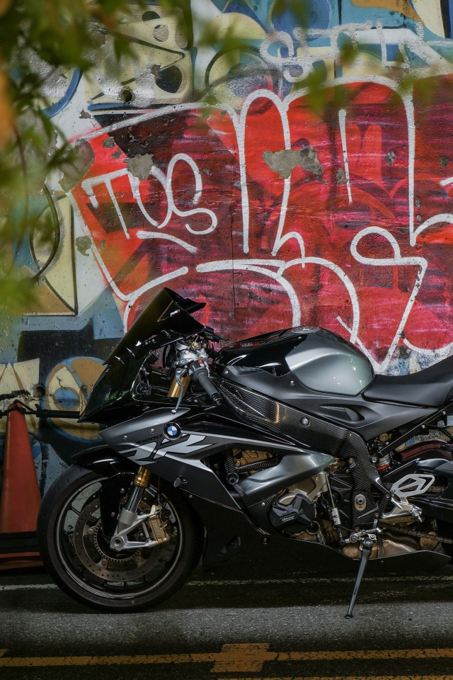 Черный мотоцикл BMW S1000RR на фоне разрисованной стены