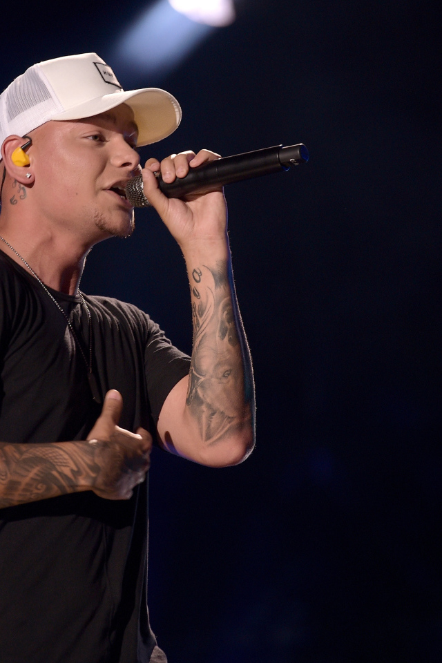 Американский кантри певец Кейн Браун с микрофоном на сцене