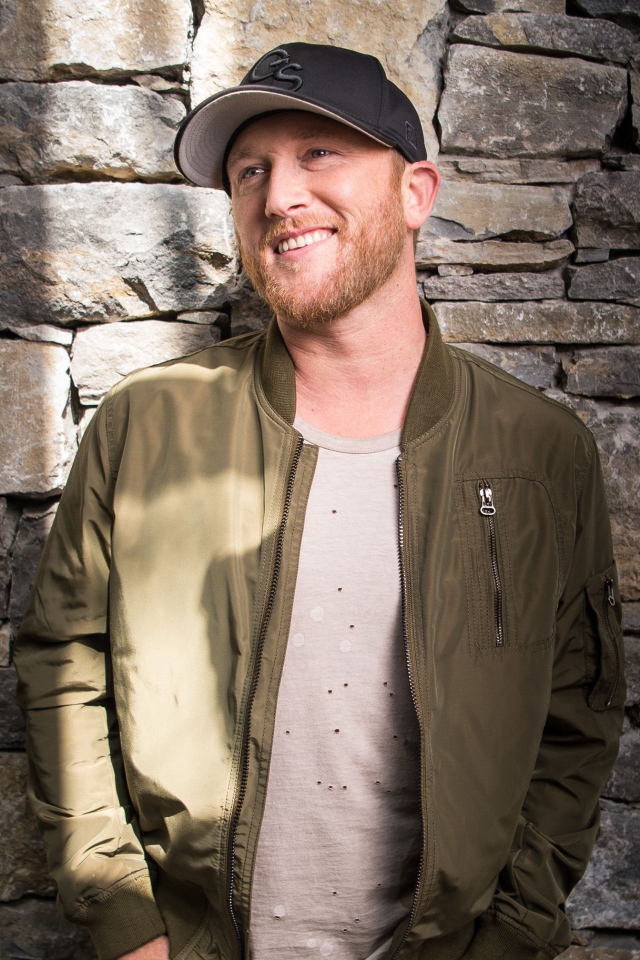 Музыкант Коул Суинделл в бейсболке у стены