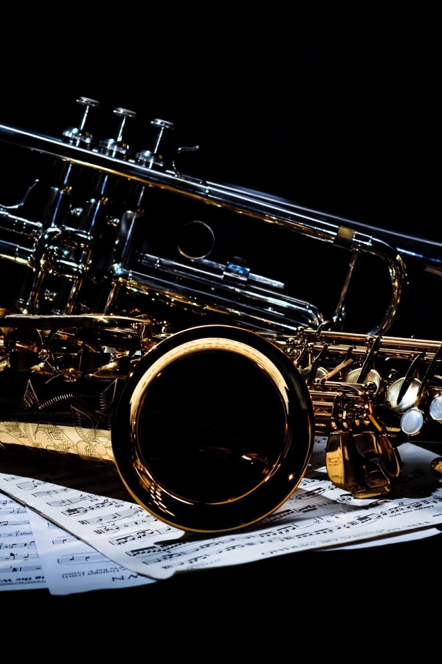 Саксофоны на нотах на черном фоне