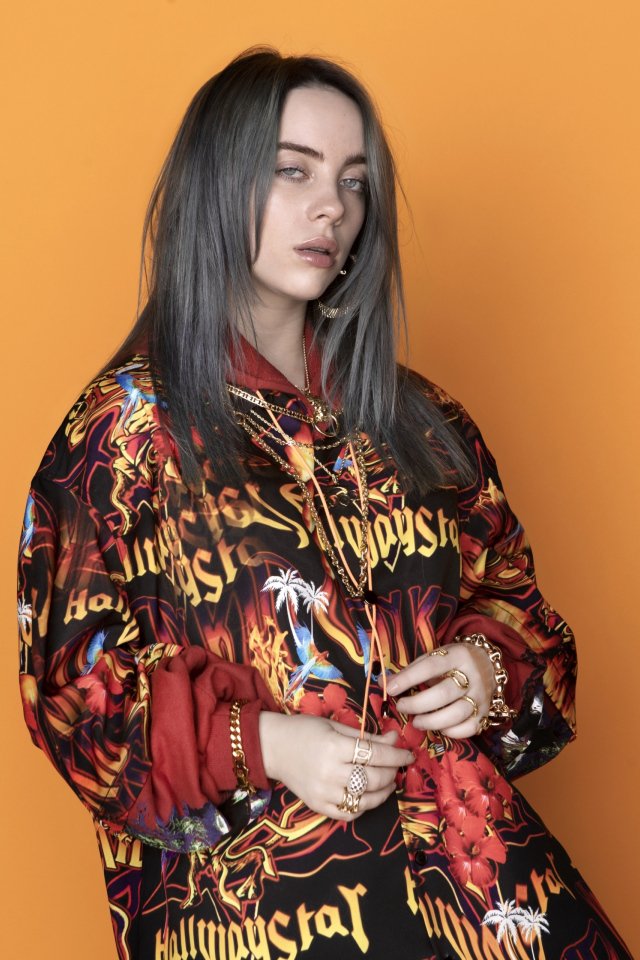 Певица Билли Айлиш на оранжевом фоне