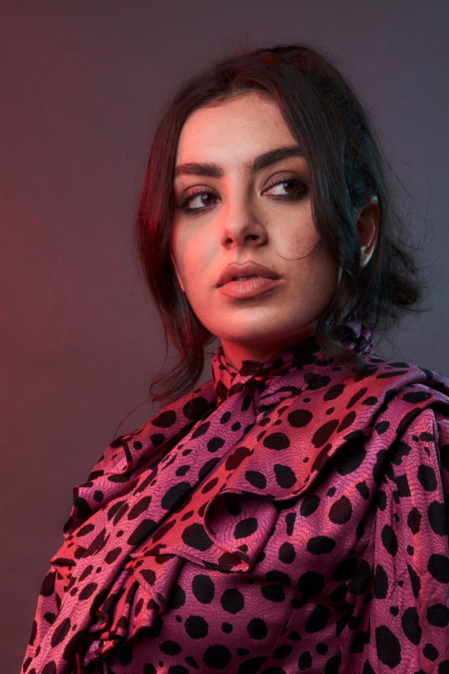Певица Charli XCX на сером фоне