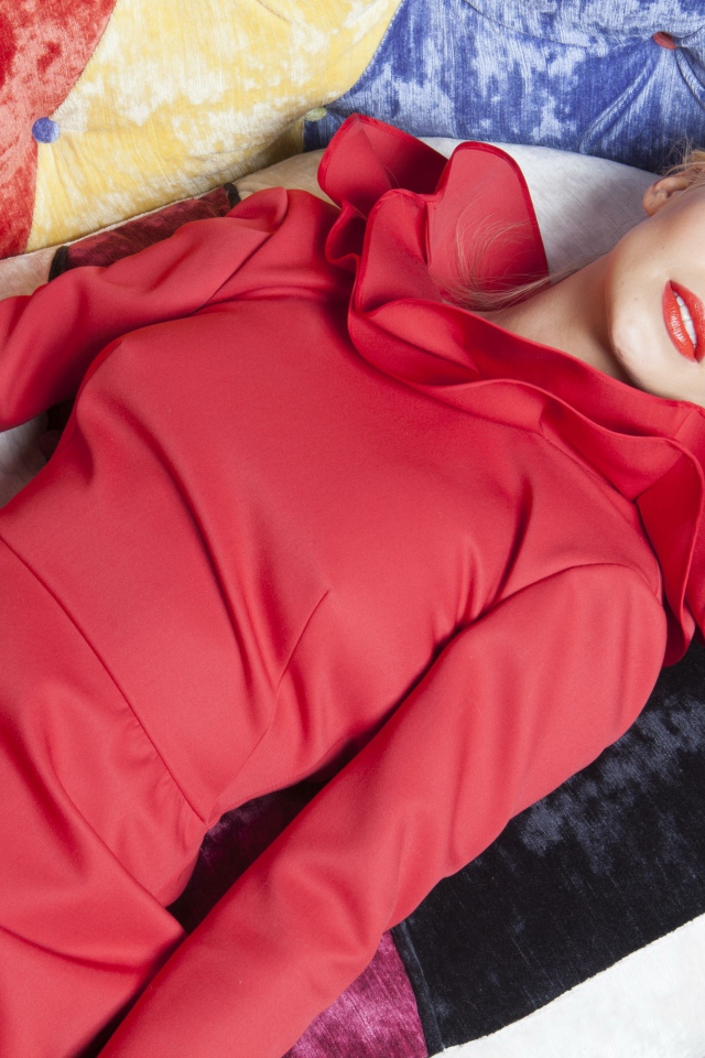 Певица Глюкоза в красном платье на кровати