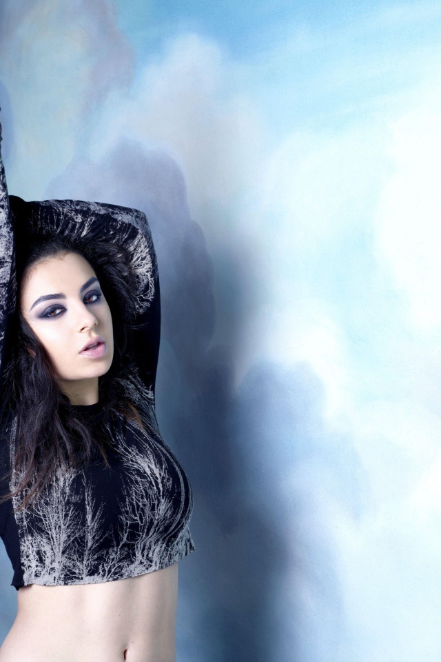 Молодая исполнительница Charli XCX  на голубом фоне