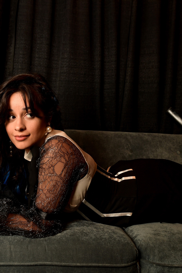 Молодая певица Камила Кабельо лежит на диване