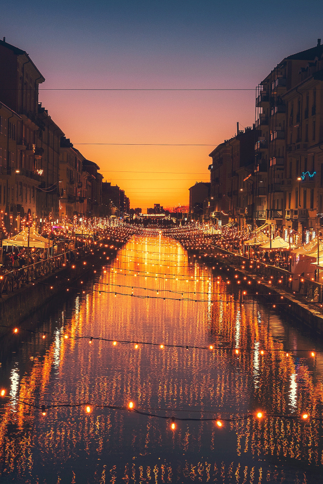 Яркие зажженные лампы над водным каналом