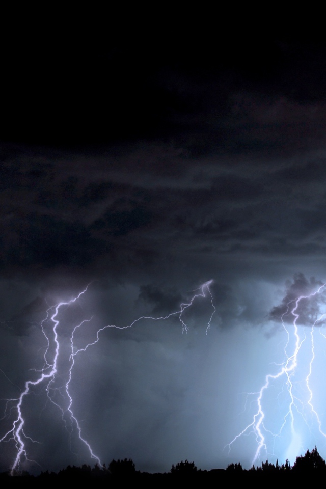 Яркие молнии в черном грозовом небе ночью