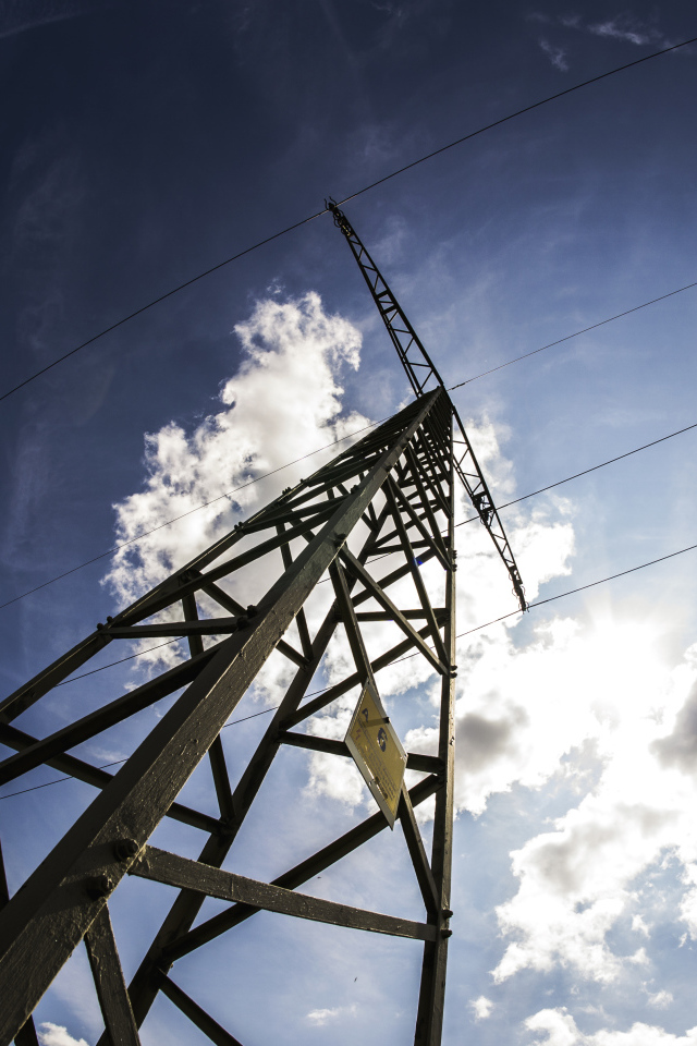 Столб линии электропередач на фоне голубого неба с облаками