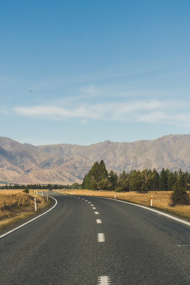 Ровная асфальтовая дорога на фоне гор 