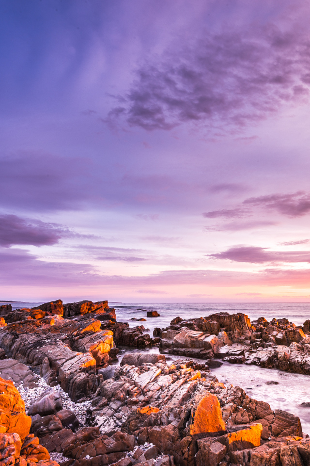 Каменный берег в море на закате солнца