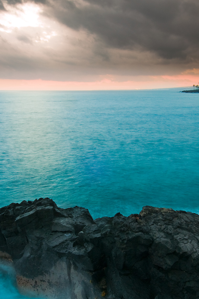 Камни в голубой воде океана под пасмурным небом