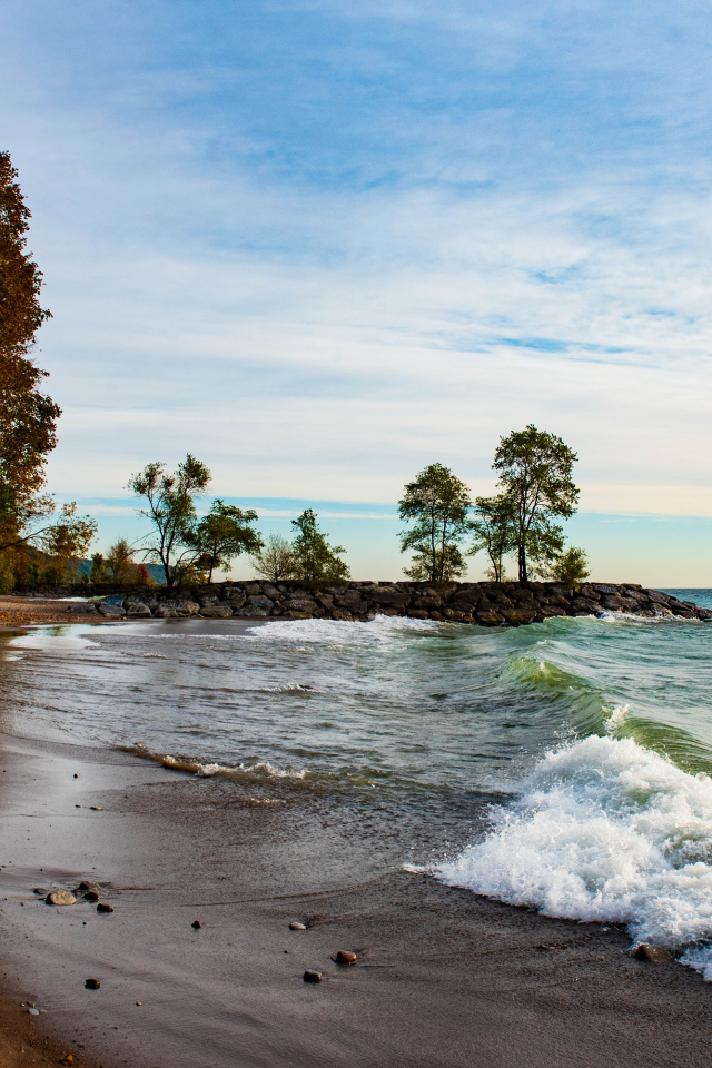 Белые волны океана на мокром песке под красивым небом