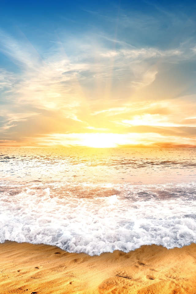 Белые волны на желтом песке на закате солнца 