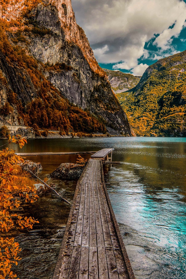 Деревянный мост в воде на фоне гор 
