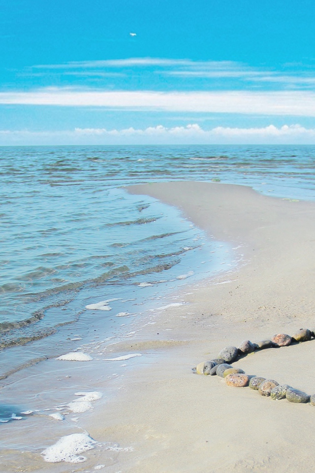 Сердце из камней на берегу теплого моря летом