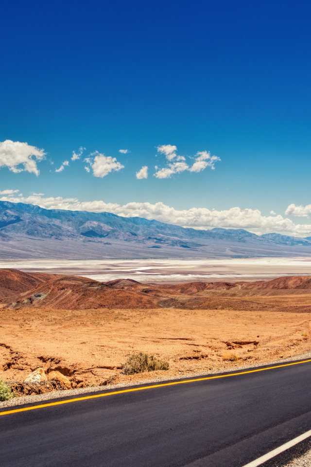 Дорога в пустыне под красивым голубым небом с белыми облаками