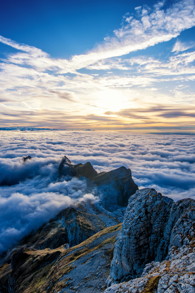 Густые белые облака над вершинами гор на рассвете