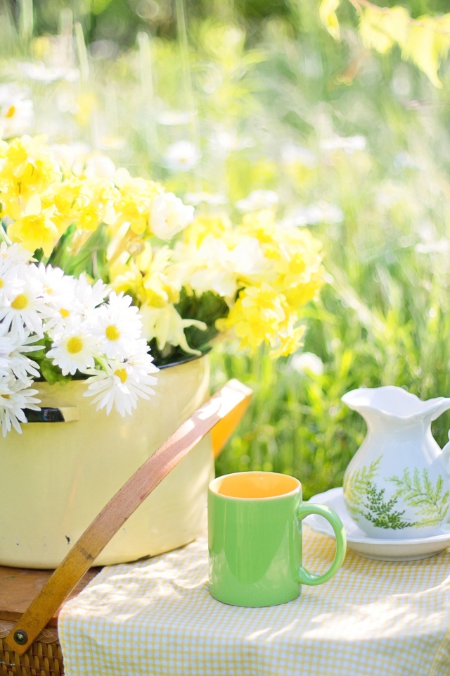 Букет цветов в кастрюле стоит на корзине 