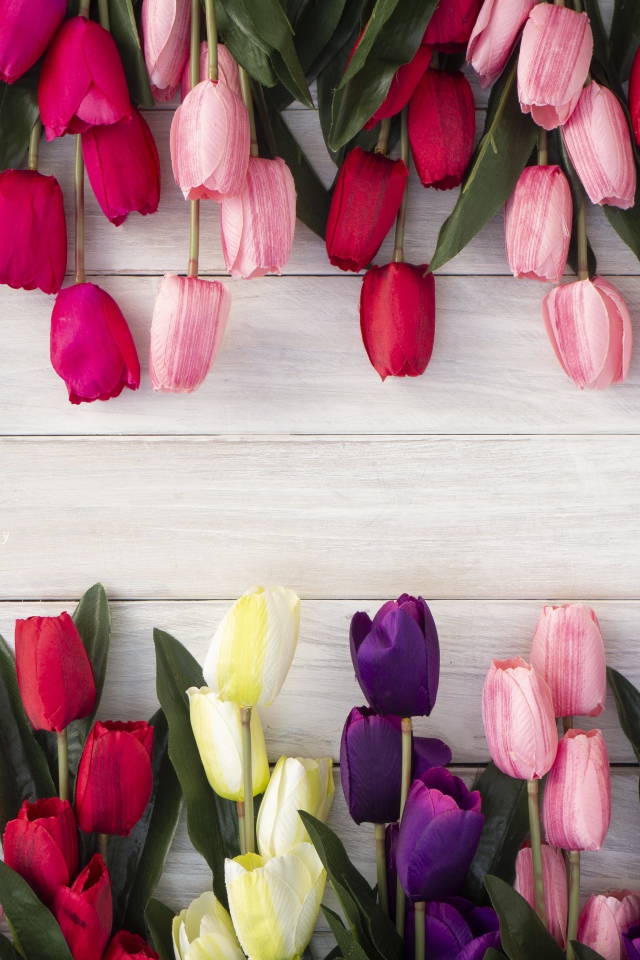 Искусственные разноцветные тюльпаны на деревянной поверхности