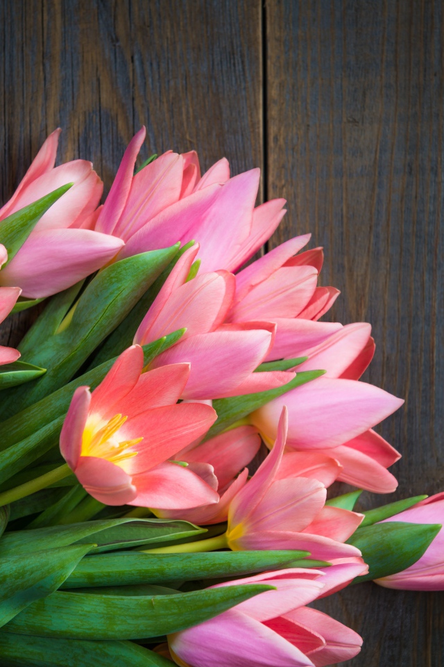 Красивый букет розовых тюльпанов на деревянном столе