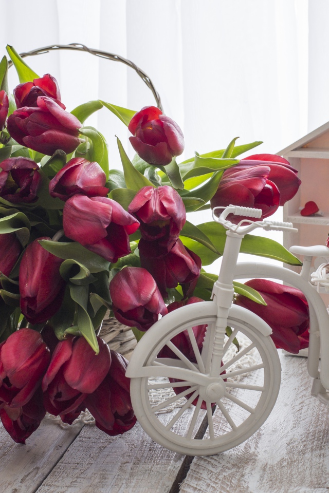 Красивый букет красных тюльпанов на столе с клубникой 