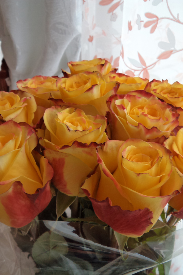 Красивый букет желтых роз в вазе у окна