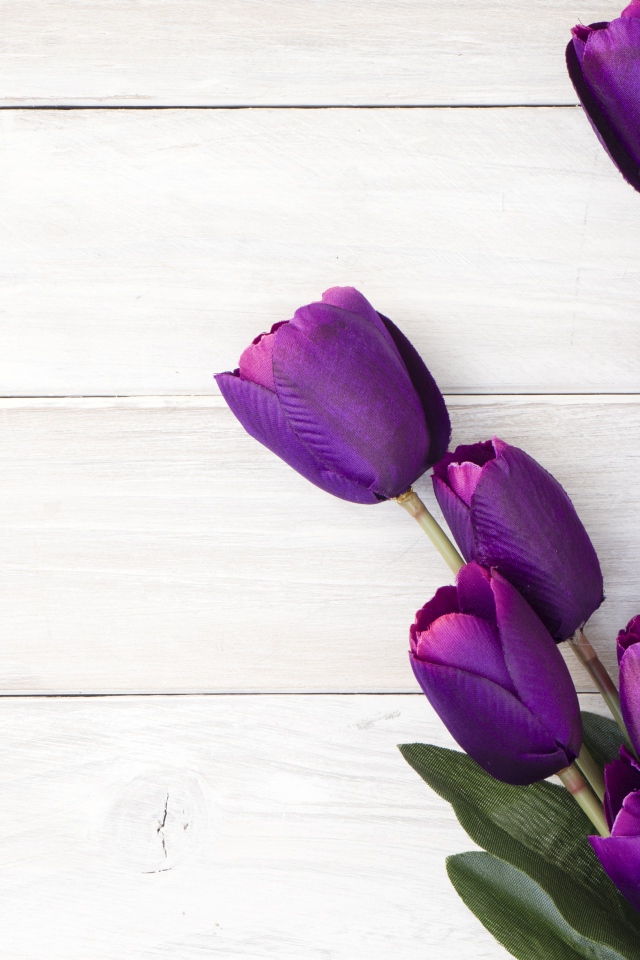 Букет искусственных фиолетовых тюльпанов на деревянном фоне