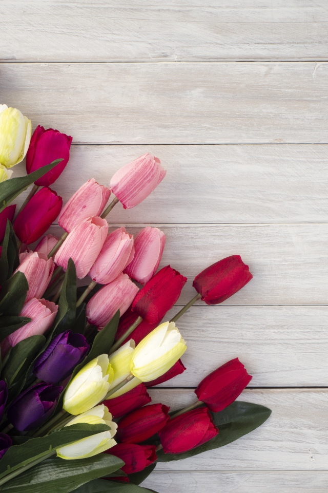 Букет искусственных тюльпанов на серой деревянной поверхности