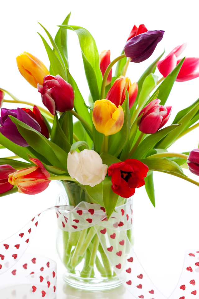 Букет разноцветных тюльпанов в прозрачной вазе с лентой 