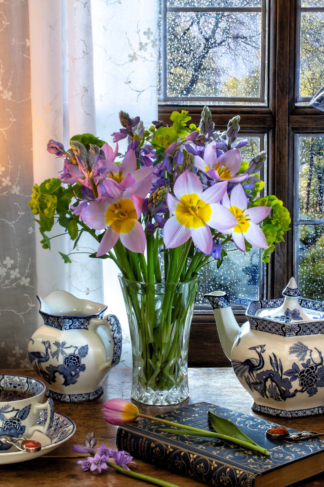 Букет цветов в вазе на столе с красивым сервизом