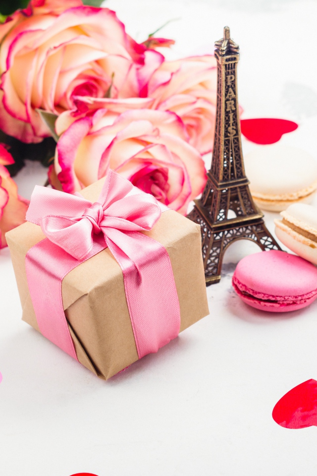 Букет роз на столе с фигуркой Эйфелевой башни и подарком